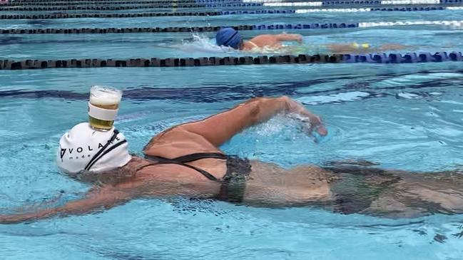 Olympic swimming champion and Nova 106.9 breakfast host Susie O'Neill swims a lap of the Fortitude Valley pool balancing a glass of beer on her head.