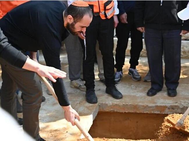 Yarden Bibas covering the coffin of his wife Shiri and sons Ariel and Kfir during the slain hostages' funeral near Kibbutz Nir Oz, February 26, 2025. (Eitan Uner/Hostages and Missing Families Forum)