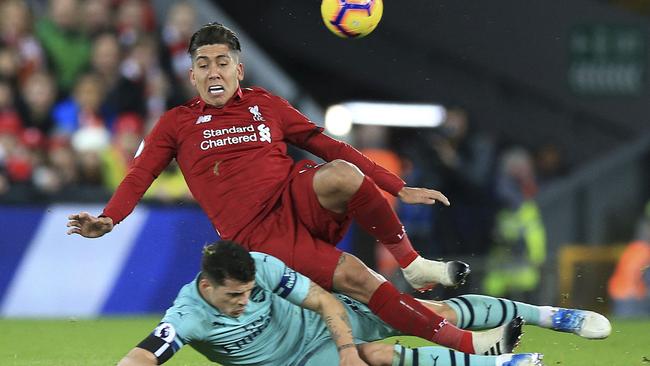 Arsenal's Granit Xhaka challenges Liverpool's Roberto Firmino, top, during their English Premier League soccer match at Anfield in Liverpool overnight. Picture: AP