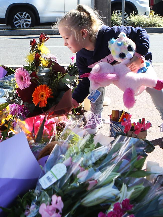 Aylah, 6, leaves a fluffy toy at the memorial. Picture: AAP/ Ric Frearson