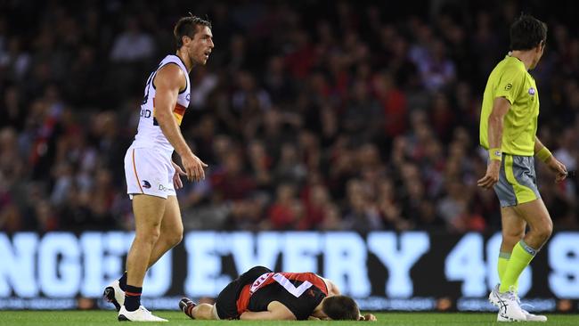 Richard Douglas of the Crows stands over Zach Merrett of the Bombers after their collision on Friday night. Picture: AAP Image/Julian Smith