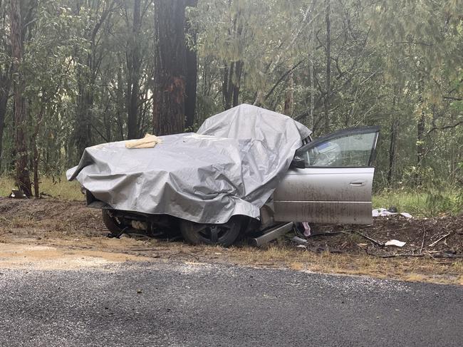 The vehicle, which collided with a tree on Pringles Way, Lawrence, is covered with a tarp to protect it from the rain prior to crash investigators arriving on scene.