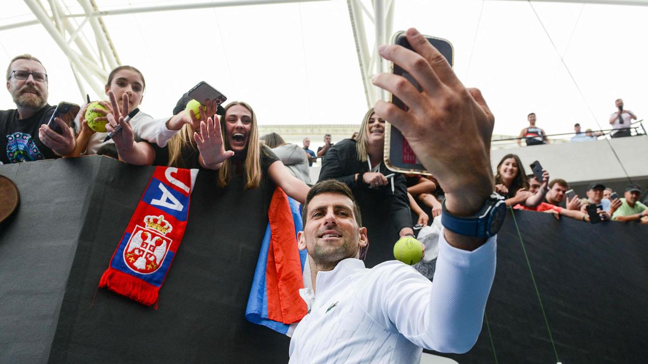 Serbian tennis player Novak Djokovic takes selfies with fans after winning his first round match against France's Constant Lestienne in Adelaide. (Photo by Brenton EDWARDS / AFP)