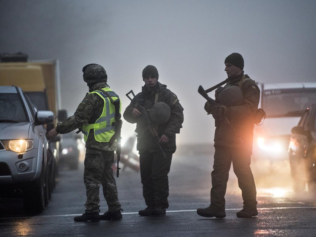 Ukrainian national guard soldiers and a police officer stop a car to check documents at the checkpoint near the city of Mariupol. Picture: AP