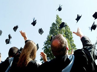 Group of university graduates throwing their mortarboards up in the air on graduation in generic photo for private education provider Navitas.