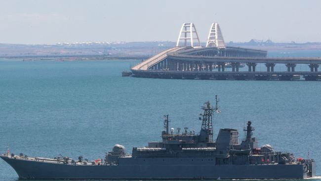 A Russian warship sails near the Kerch bridge, linking the Russian mainland to Crimea, following an attack claimed by Ukrainian forces. Picture: AFP