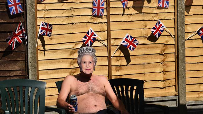 Terry Livesey wears a mask of Queen Elizabeth II while sunbaking in his garden in Portslade, southern England. Picture: AFP