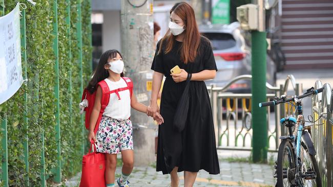 A mother and her daughter walk to school in Seoul, South Korea, on Tuesday. Picture: AFP