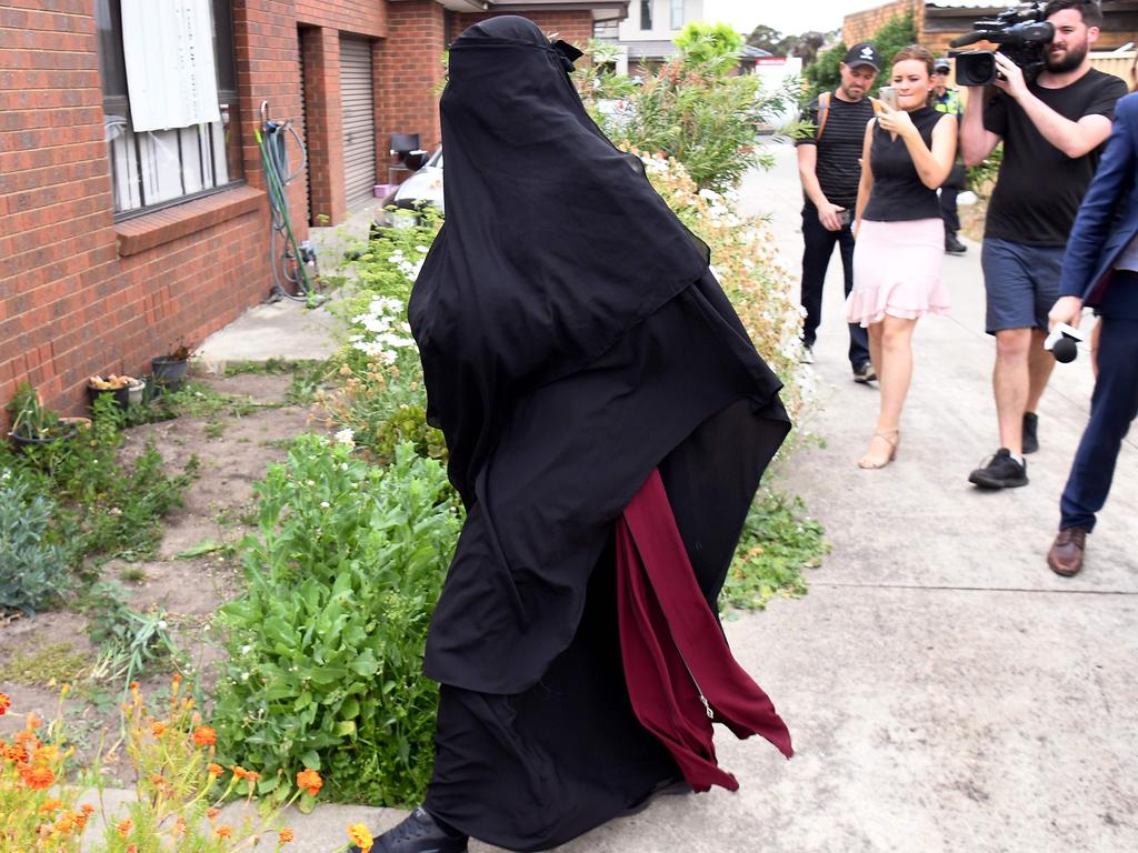 The woman enters a house raided by police in the Melbourne suburb of Dallas. Photo: William West/AFP.