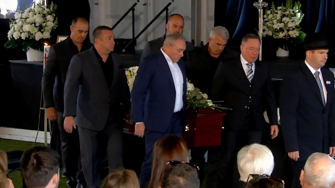 The pallbearers take Paul Green’s coffin away.