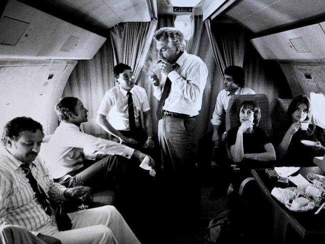 TAUS 60th Anniversary. New Labor and Opposition leader Bob Hawke surrounded by advisors and media (L-R) journalist Colin Parks, Senator Kerry Sibraa, journalist Peter Logue, senior advisor Geoff Walsh, staffers Kate Moore and Janet Willis, lights up a cigar on a VIP flight during the 1983 Federal Election Campaign, which saw Labor swept to a landslide victory. Pic Ray Strange.