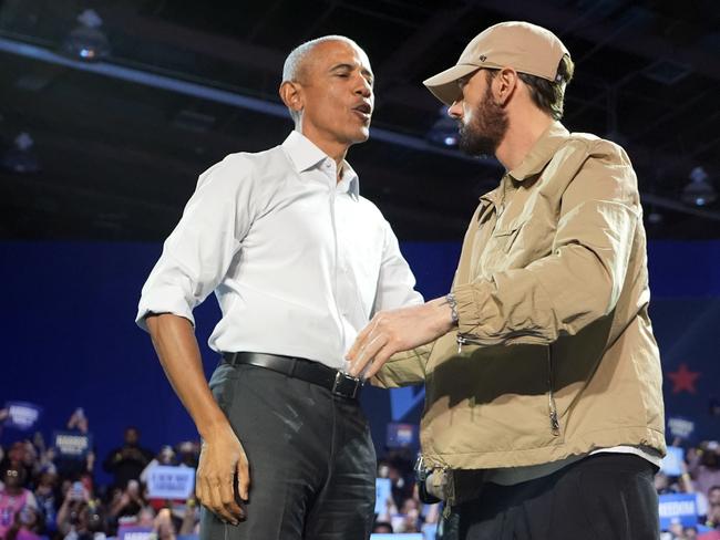 Rapper Eminem, right, greets former President Barack Obama, left, on stage at a campaign rally supporting Democratic presidential nominee Vice President Kamala Harris, Tuesday, Oct. 22, 2024, in Detroit. (AP Photo/Paul Sancya)