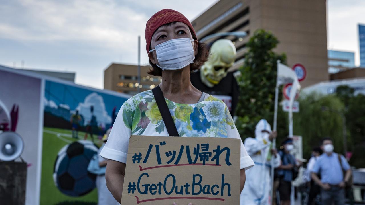 A woman holds a placard saying 'Get Out Bach'.