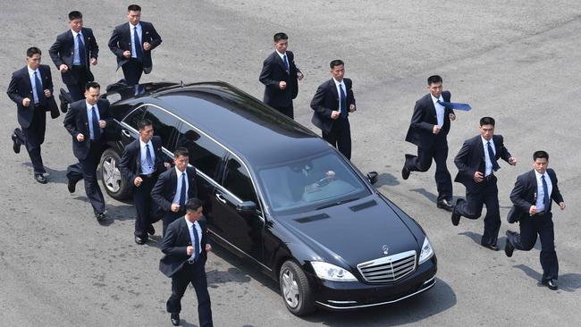 North Korean bodyguards jog next to Kim Jong-un’s car. Picture: AFP PHOTO.