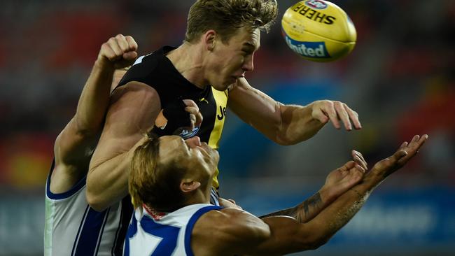 North Melbourne’s Kyron Hayden is knocked out after running back into the path of Tiger Tom Lynch.