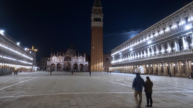 People walk in an almost empty St. Mark's Square in Venice. Picture: AP