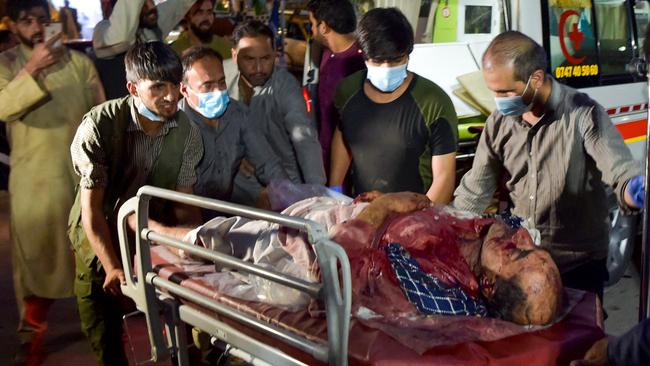 Volunteers and medical staff rush an injured man for treatment after two huge explosions rocked the Kabul airport precinct. Picture: AFP