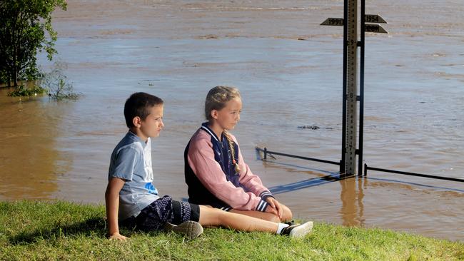 Jack Enright, 11, and Jasmin Maycock,10, watch at the Fitzroy River flood gauge as floodwaters continues to rise in Rockhampton. Picture: Tim Marsden