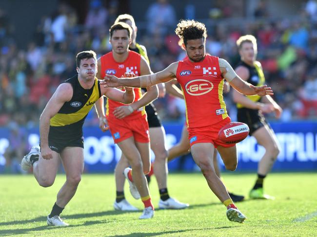 Jarrod Harbrow of the Suns (right) kicks the ball during the Round 21 AFL match between the Gold Coast Suns and the Richmond Tigers at Metricon Stadium on the Gold Coast, Saturday, August 11, 2018. Picture: AAP Image/Darren England