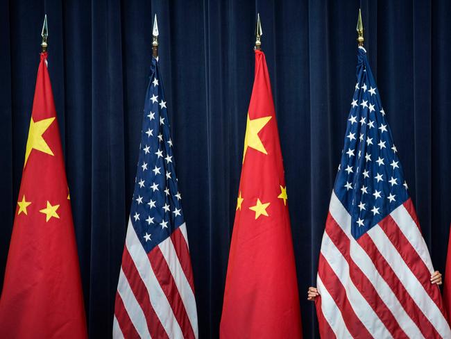 (FILES) In this file photo taken on July 10, 2013, a staff member adjusts a USn flag before the opening session of the US and China Strategic and Economic Dialogue at the US Department of State in Washington, DC.   The White House said on May 29, 2018, the planned trade sanctions against China announced in March are still in the works, and details will be announced in the coming month. Despite announcing a truce in the trade hostilities, after US Treasury Secretary Steven Mnuchin said threatened tariffs on Chinese goods were "on hold," the White House signaled it was ready to pull the trigger on a broad array of penalties. / AFP PHOTO / Brendan SMIALOWSKI