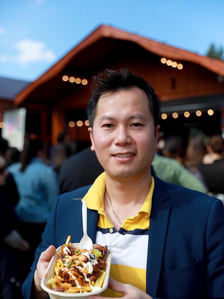 Nam Tran from Guildford holds a Hot and spicy pork belly meal from Tsuru at the Cherry Blossom Festival in Auburn (AAP IMAGE / Angelo Velardo)