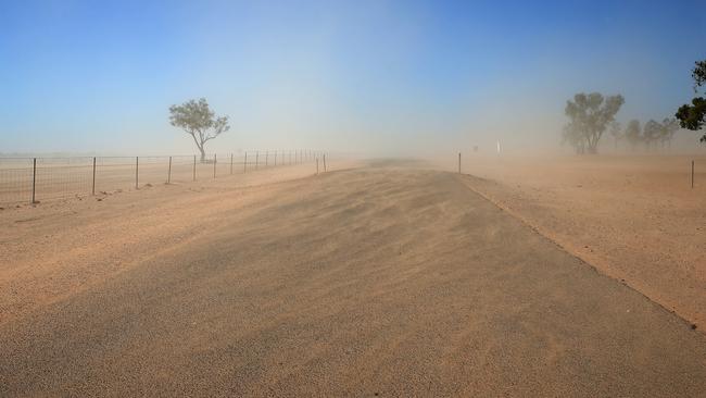 Driving through a haze of dust as winds pick up dirt outside of the small township of Louth in the far west of NSW. Picture: Toby Zerna