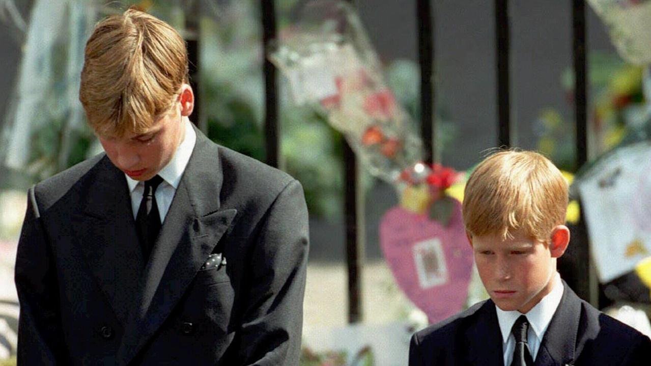 Prince William and Prince Harry bow their heads as their mother's coffin is taken out of Westminster Abbey following her funeral service. Picture: AP Photo/Adam Butler