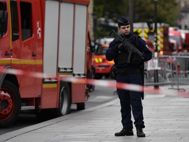 A policeman stands next to firefighter vehicles near Paris police headquarters. Picture: AFP