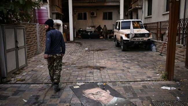 A defaced portrait of Bashar al-Assad lies outside an intelligence facility in Damascus after he was driven out of Syria. Picture: Aris Messinis/AFP/Getty Images