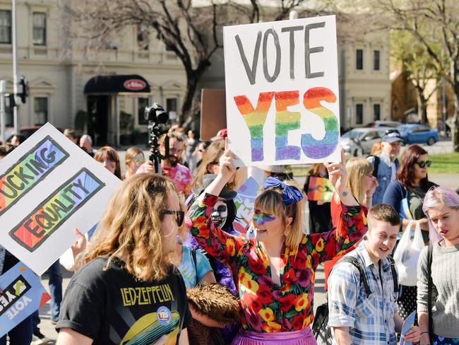 A supporter is seen with a 'Vote Yes' sign on King William St during the march at the "Yes" To Marriage Equality Rally at Parliament House, Adelaide. Picture: AAP