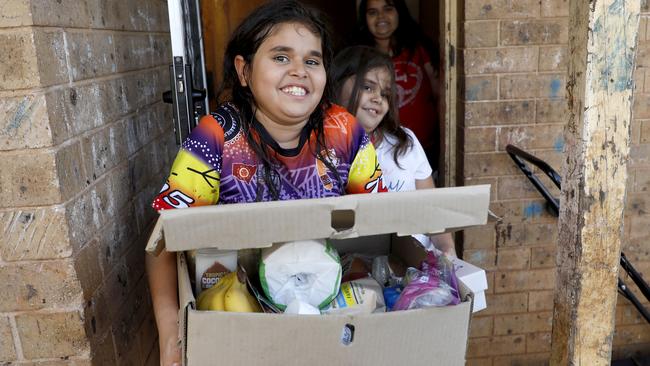 Tammie Fernando, 10, collects a food hamper delivered to her family’s doorstep in Dubbo. Picture Chris Pavlich