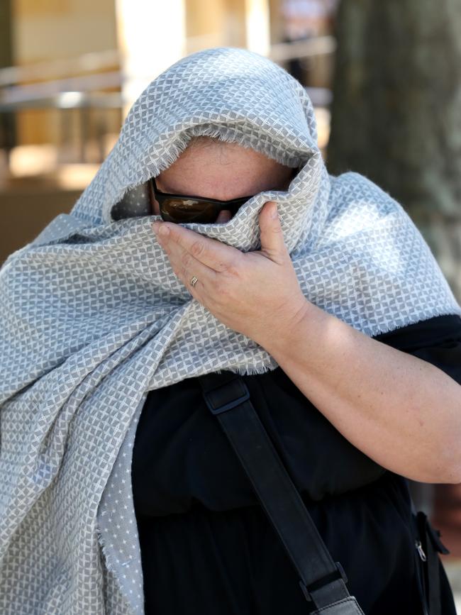 Helena Heaft covers her face as she leaves the Adelaide Magistrates Court on October 11, 2019. Picture: Kelly Barnes.