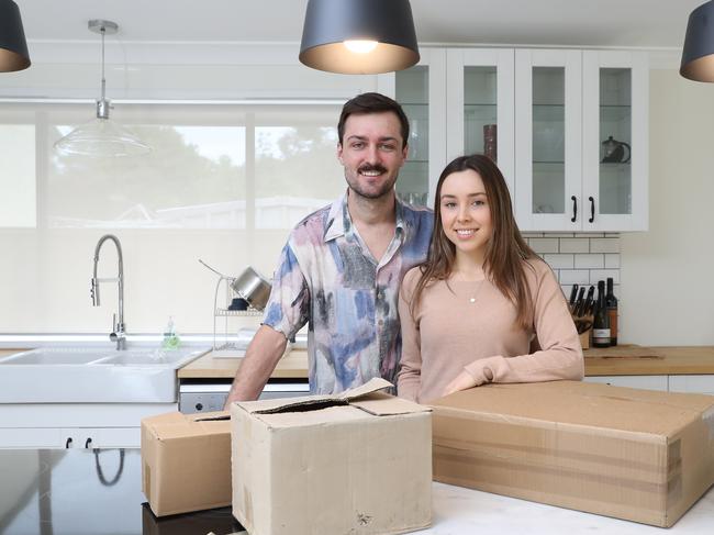 Jarrod Redmond, 23, and Rebecca Michelsen, 21, pose for a photo at their new home today, October 6, 2018. The young couple have successfully bought their first home at in Emu Heights. (AAP Image/David Swift)