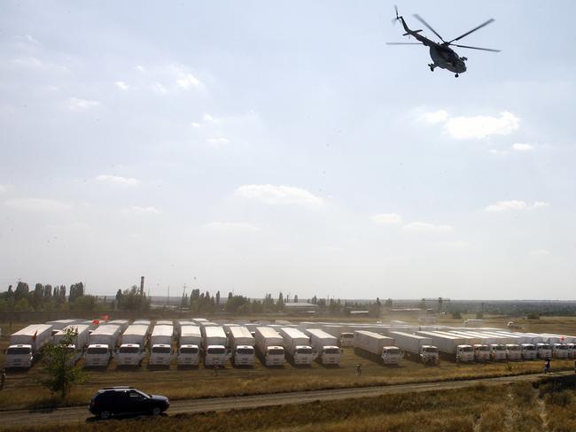 A helicopter flies over trucks from a Russian humanitarian convoy parked on a field outside the town of Kamensk-Shakhtinsky in the Rostov region, some 30kms from the Russian-Ukrainian border. Picture: Andrey Kronberg