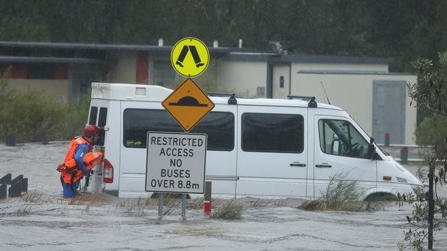 SES crews wade to an empty van at Narrabeen lagoon / Picture: John Grainger