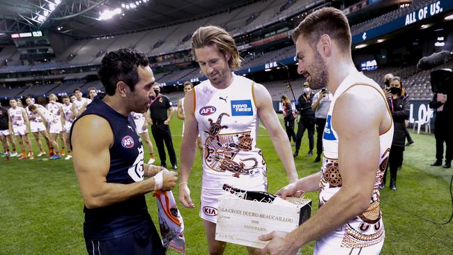 Eddie Betts is presented with a gift by GWS stars Callan Ward and Stephen Coniglio. Picture: Getty