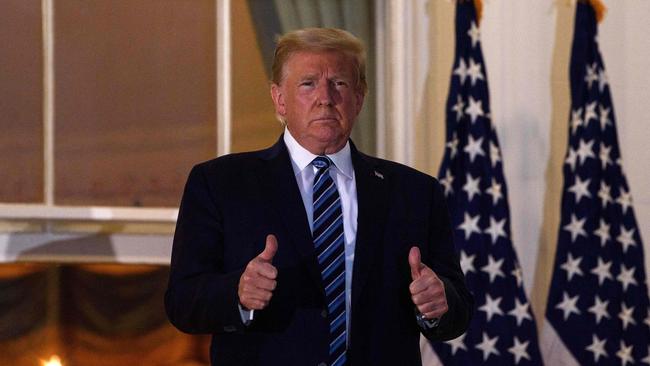 US President Donald Trump gives two thumbs up from the Truman Balcony upon his return to the White House from Walter Reed Medical Center, where he underwent treatment for Covid-19.