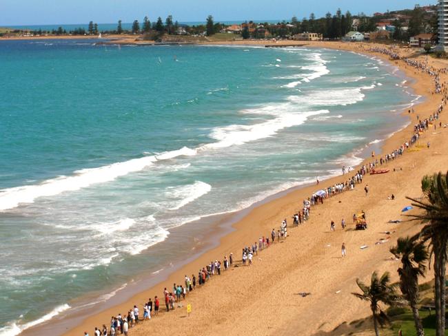 Protesters linking arms on the beach in 2002.