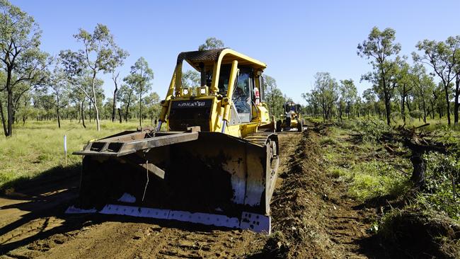 Earthmoving equipment starts construction of a mine access road at the Adani Carmichael coal mine in the Galilee Basin.