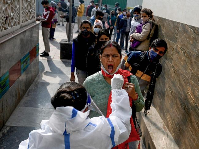 A health worker performs coronavirus tests on people in New Delhi in January. India has announced the end of all Covid restrictions. Picture: AFP