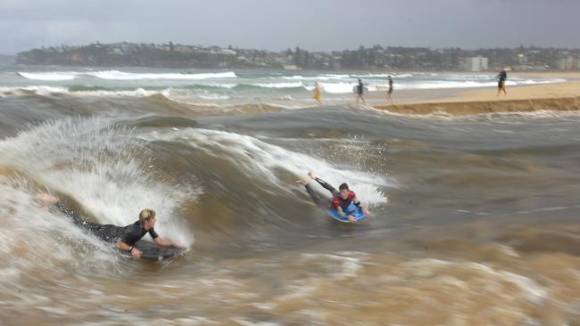 Bodyboarders enjoying the opening of Dee Why Lagoon in 2007 by using the standing waves created by the current. Picture: Martin Lange