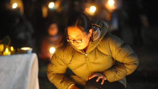 A woman stops to reflect at a gathering to support the family of Qi Yu in Berowra. Picture: Jake McCallum