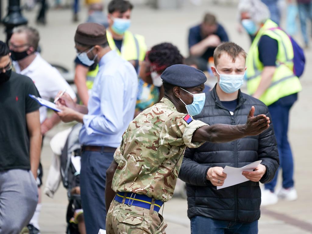 Soldiers from the Royal Horse Artillery guide members of the public at a rapid vaccination centre in Bolton, UK.