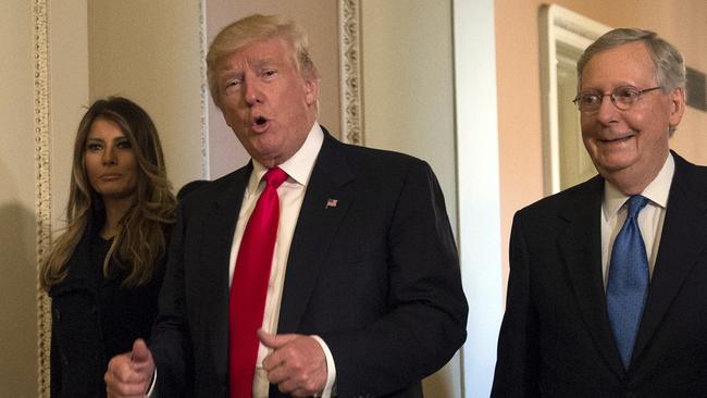 President-elect Donald Trump, accompanied by his wife Melania, and Senate Majority Leader Mitch McConnell gestures while walking on Capitol Hill in Washington. Picture: Molly Riley/AP