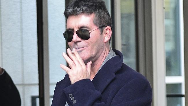 Simon Cowell smoked a cigarette outside Lauren Silverman's hospital.