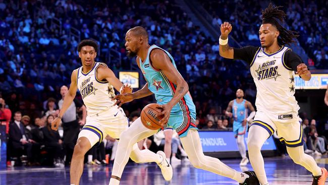 Kevin Durant (middle) drives to the rim against the Rising Stars squad. Ezra Shaw/Getty Images/AFP