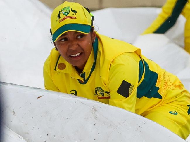 MELBOURNE, AUSTRALIA - OCTOBER 12: Australian players assist ground staff in carrying the pitch covers as the rain comes in during game two of the womens One Day International series between Australia and the West Indies at Junction Oval on October 12, 2023 in Melbourne, Australia. (Photo by Asanka Ratnayake/Getty Images)