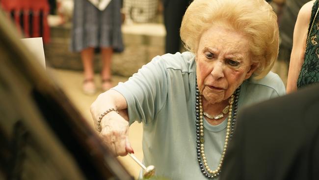 Bill Waterhouse’s widow, Suzanne, splashes holy water on his coffin during the funeral. Picture: AAP Image/Mark Evans