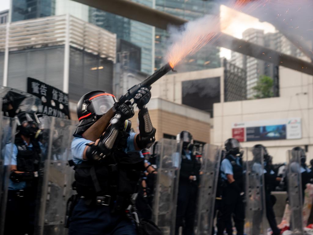 A police officer fires tear gas during a protest. Picture: Anthony Kwan/Getty