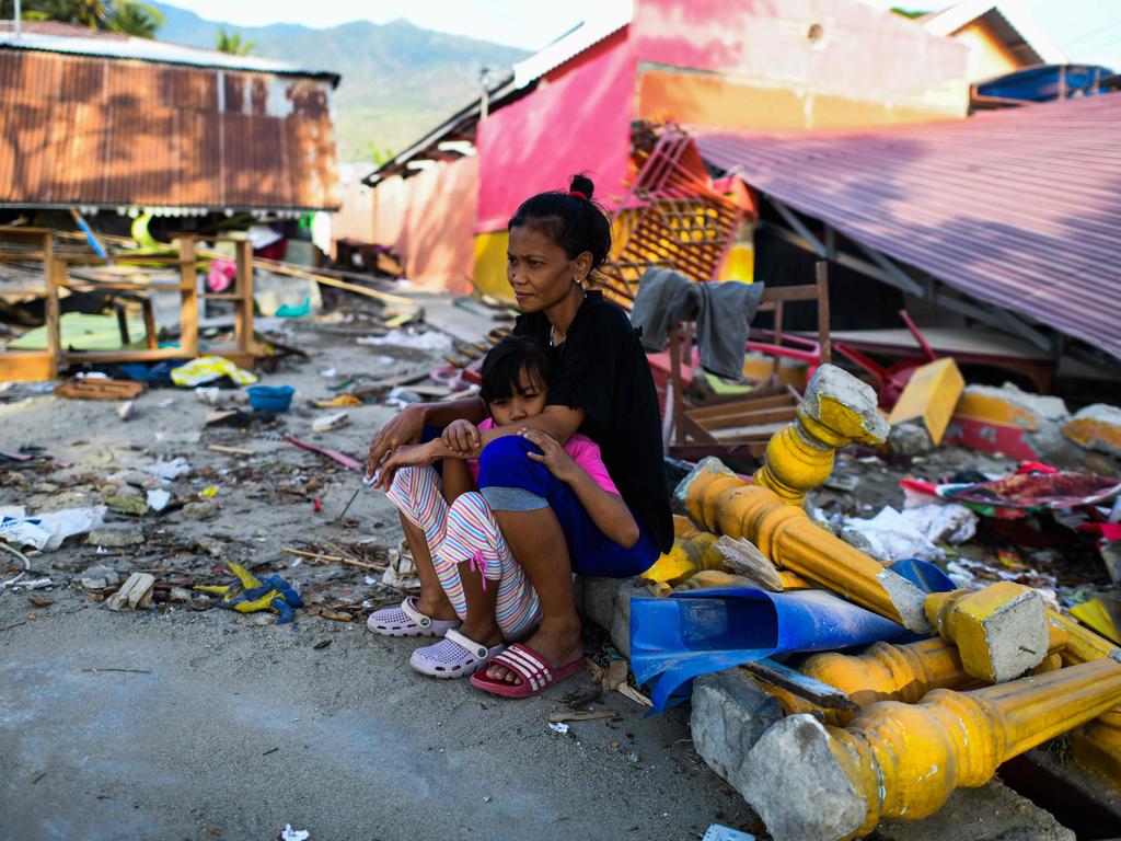 An earthquake-affected woman and her child sit among the rubble of their collapsed house on the outskirts of Palu in Indonesia's Central Sulawesi. Picture: Jewel Samad